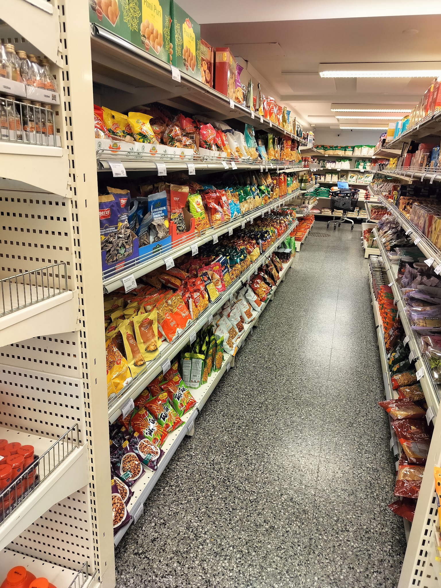 A stocked grocery aisle inside Al-Fateh Market.