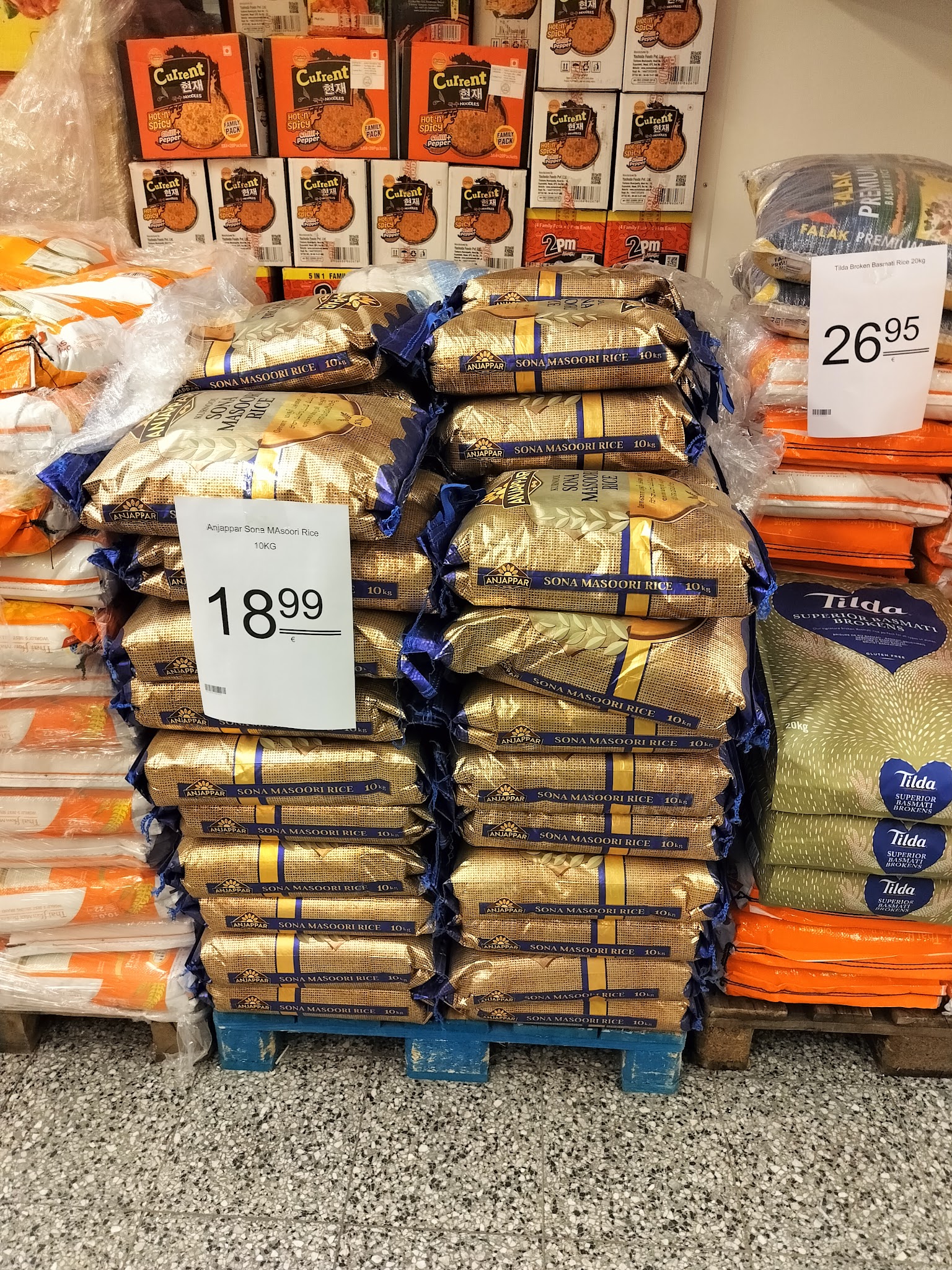 Rice and other grocery goods displayed on market shelves.