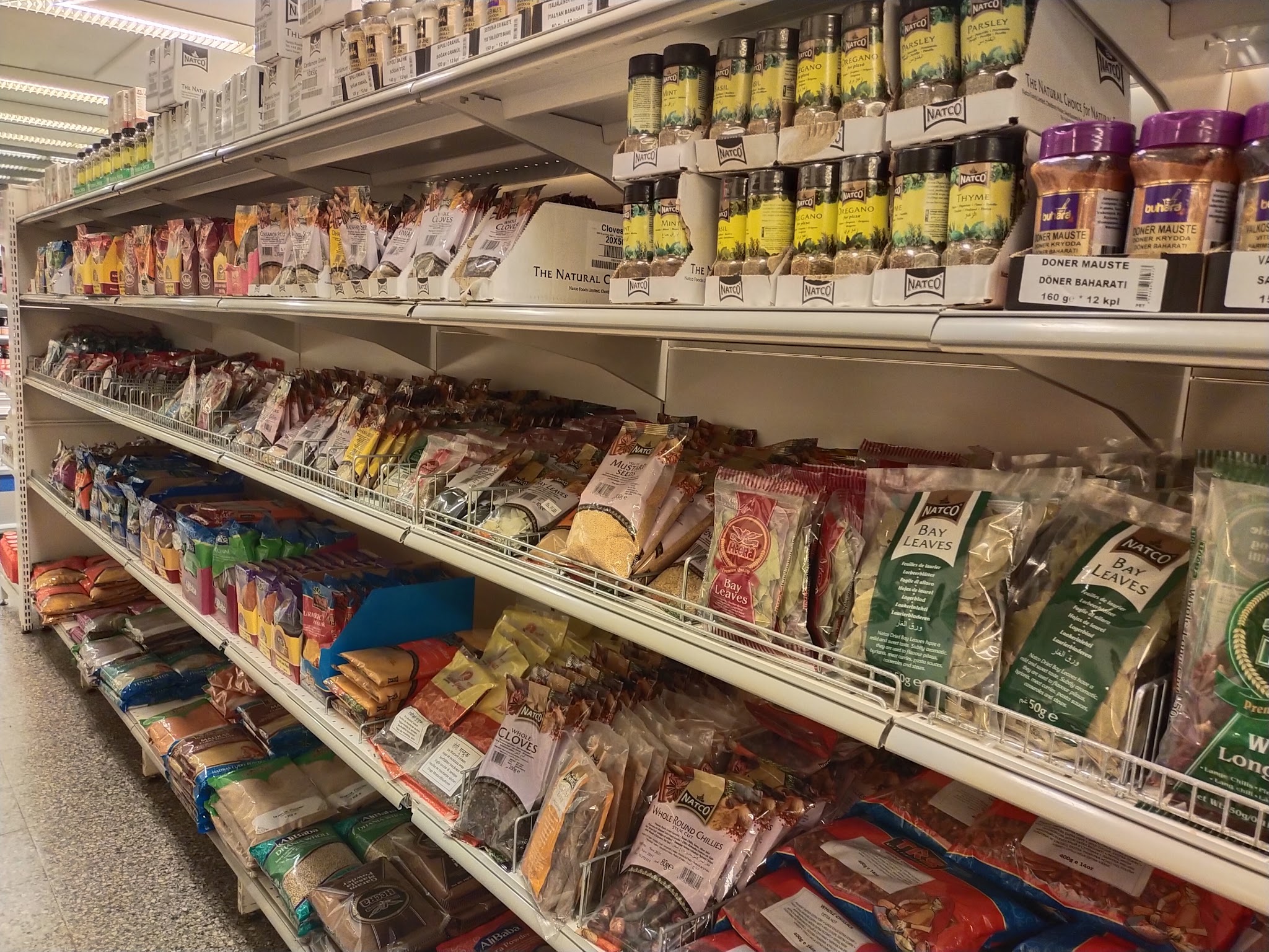 Shelves of spices and packaged foods inside Al-Fateh Market.